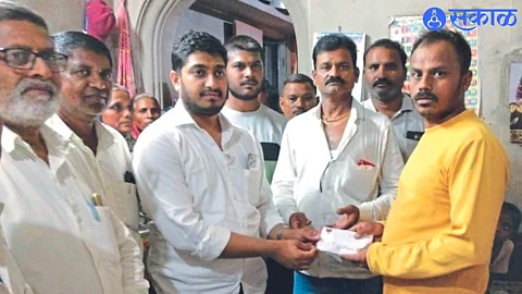 Zilla Parishad member Ram Bhadane while giving help to Purav's father Deepak Mali.