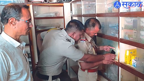 Shirpur: Sub-inspector Sandeep Murkute and constable Govind Koli while checking the prints on the glass of the rack in the shop.