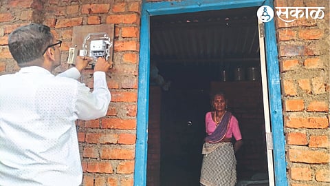 Maha distribution staff installing electricity meter at Ashok Hilam's house.