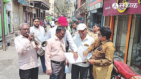 Municipal employees collecting money by playing a band in front of the houses of defaulters.