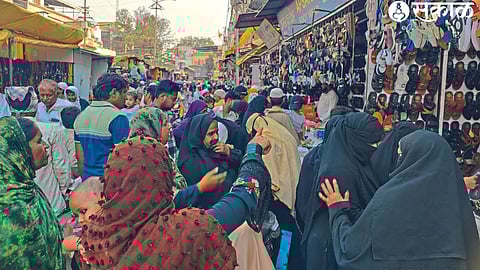 A crowd gathers to buy women's fancy slippers on Kidwai Street.