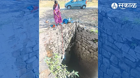 Women drawing water from a well in Audhainwadi settlement.
