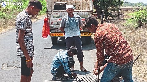 Laborers filling the fatal pothole on Sarangkheda road.