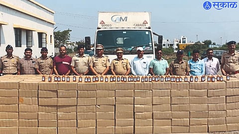 Police officers and staff with the liquor seized by the police.