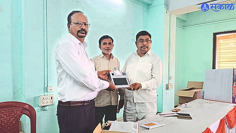 Supply Monitoring Officer Ravindra Mahadik while distributing e-pos machine to cheap grain shopkeeper at Tehsil office.