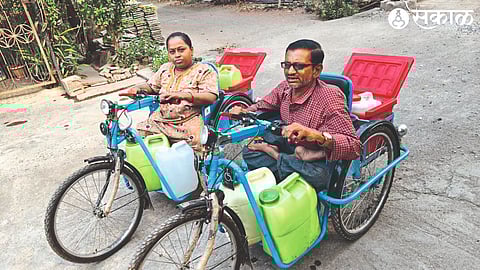 A disabled couple carrying water on a tricycle in the Vitthal Mandir area of Shiv Colony.