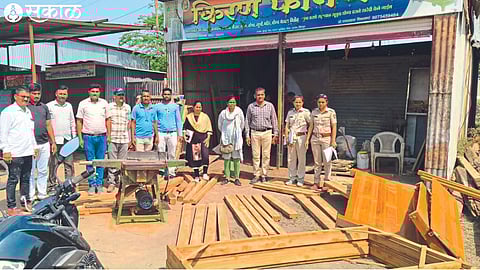 Forest department team with seized timber and machinery.