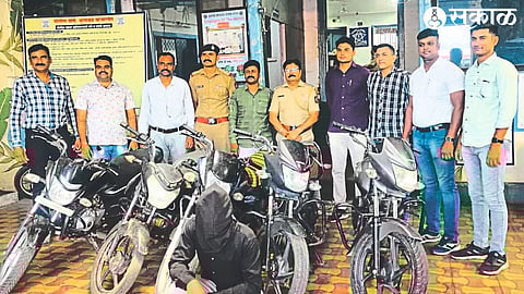 Police officers and personnel including the seized bike and the arrested suspect.