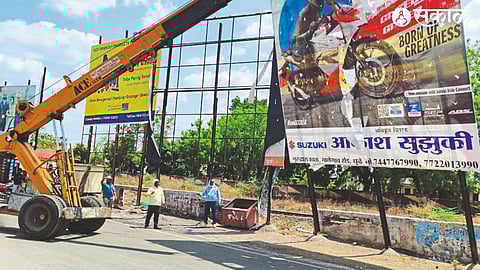 Municipal Corporation team removing unauthorized hoardings on Malegaon Road in the city.