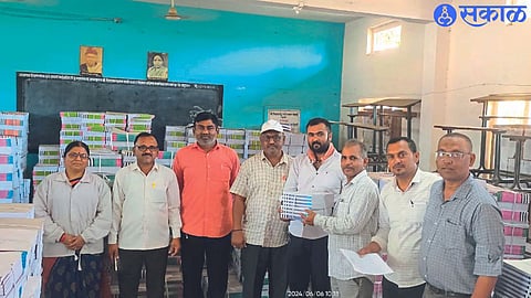 A teacher carrying textbooks to a group resource center