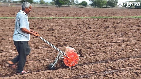 Farmer Mahendra Shantaram Borse tokens maize through a token machine in his field.