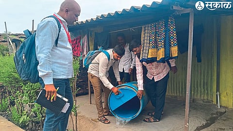 Health workers emptying water containers found with mosquito larvae