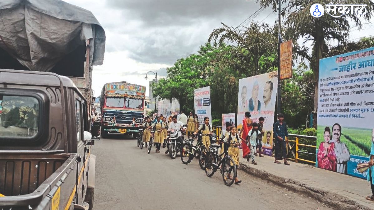 Pedestrians and school girls have to make their way through Nandgaon city in heavy vehicles.