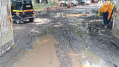 A woman entering the office wading through muddy water on the road at the GPO Post Office