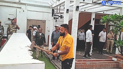 Workers breaking encroachment with hammer.