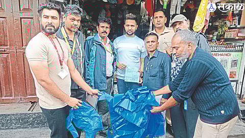 The team confiscating plastic bags from a businessman's shop at Dood Bazar.