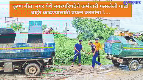Municipal employees pulling out the hourglass stuck in the mud in Krishna Gitanagar.
