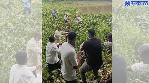 A team of disaster management and fire brigade while removing the body of a dead youth from the Godavari riverbed at Gangawadi.