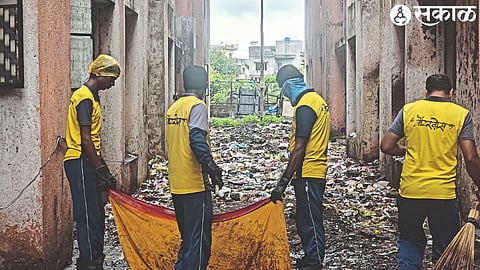 Sanitation workers while cleaning the garbage from the building area.