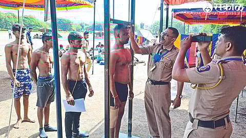 A policeman measuring the height of candidates during a physical test at the police drill ground on Sunday as part of the Home Guard recruitment process