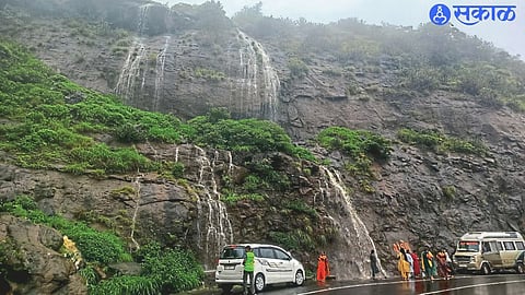 Tourists enjoying a dip in the waterfall area in the ghat area.
