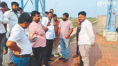 A representative of a private agency talking to protester Deepak Veljali at Pimperwadi toll road.