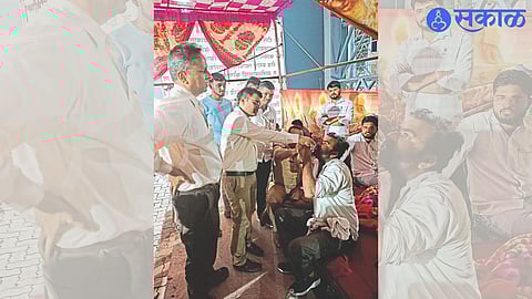 Deepak Veljali along with barber Dilip Patil while suspending the food boycott movement by taking lemonade from Naib Tehsildar Sagar Mundada.