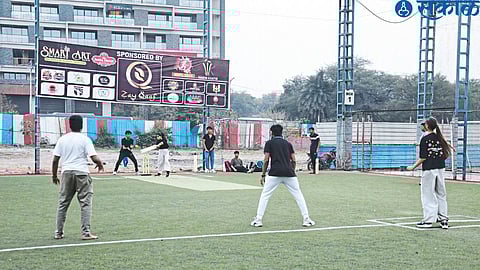 Young men and women playing box cricket here.