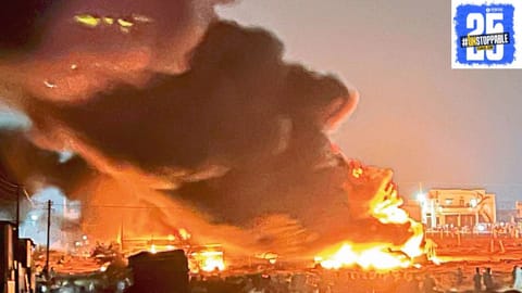 Massive fire at scrap and plastic factory controlled by firefighters using five trucks."