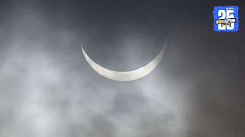 A breathtaking view of the 2025 partial solar eclipse as the moon partially obscures the sun, creating a stunning crescent-shaped glow in the sky.