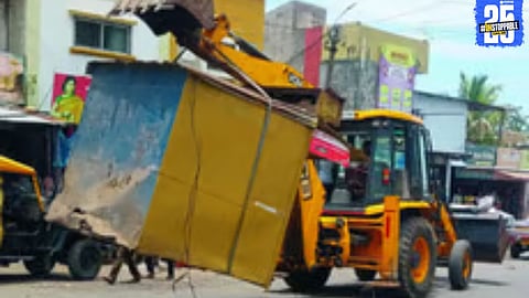 Civic officials removing unauthorized construction near Dhebewadi bus stand during encroachment drive.