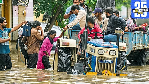 Rescue personnel evacuate stranded citizens in a flooded Bengaluru locality using boats after incessant rainfall.