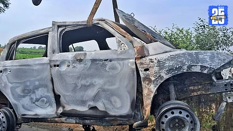 Charred remains of a car after it collided with a bridge due to a driver's error, killing five passengers on the spot.