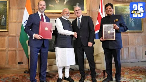Leaders of India and the UK shake hands after signing the historic Free Trade Agreement, expected to impact prices of daily commodities, electronics, and exports.