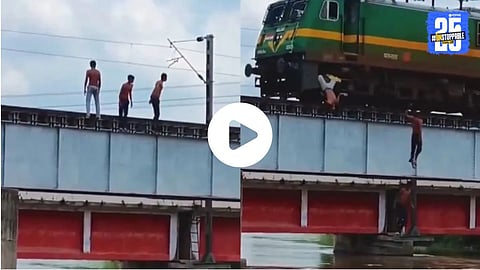 Three boys standing on a railway track bridge jump into the river as a train approaches, risking their lives for a viral reel.