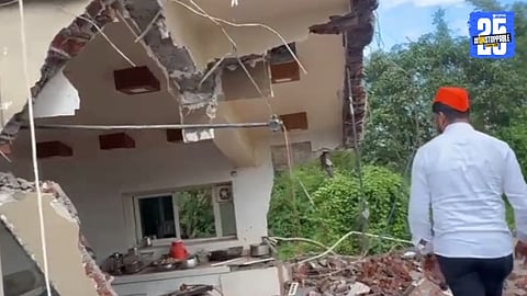 “Site of the demolished house of Hindu Sena leader Dhananjay Desai, with police presence and local residents.”