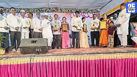 Anna Hazare felicitating social workers during an award ceremony at Ralegan Siddhi, praising their dedication to community service.