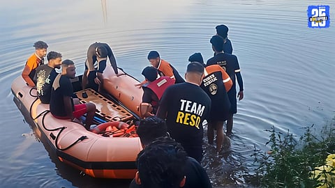 Rescue volunteers and police personnel recovering the body of a drowned cowherd from the Amba rive