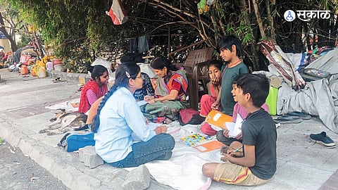 Children attending street classes near Jhansi Rani Metro Station in Nagpur, balancing work and education.