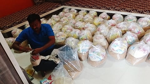 बदनापूर : गरजूंसाठी गव्हासह किराणा साहित्याची बांधणी करताना संतोष पवार.