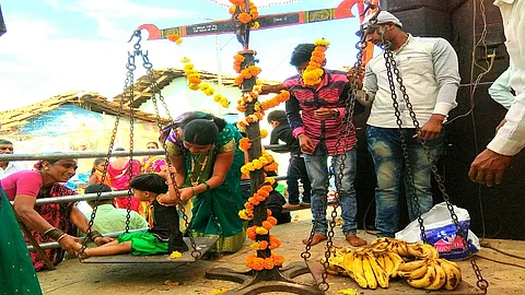 किन्हवली : नवसाने पूत्रप्राप्ती झालेल्या महिला आपल्या बाळाला वजन काट्यात त्याच्या वजना इतक्या फळांनी जोखतात.