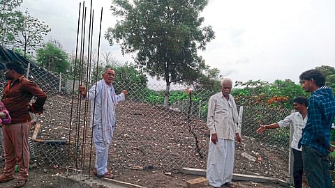 येथे लोकवर्गणीतून उभारण्यात येत असलेल्या स्मशानभूमीच्या कामाची पाहणी करताना ग्रामस्थ.