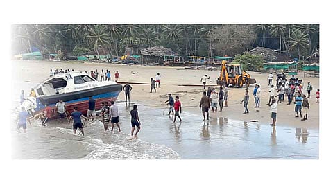 मालवण ः बंदर जेटीनजीकच्या समुद्रात बुडालेली पोलिसांची गस्तीनौका किनाऱ्यावर आणताना मच्छीमार.