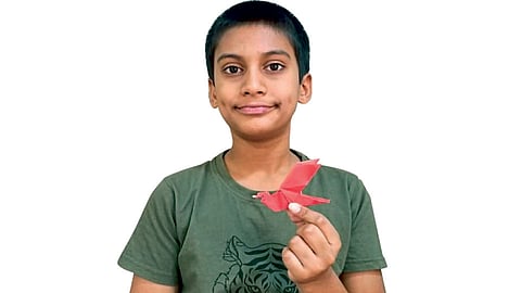 ओरिगामी कलेतून तयार केलेला पक्षी दाखविताना अभिराम जोशी.