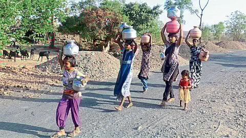 बीड - भर उन्हात डोक्यावर हंडे घेऊन पाणी वाहताना लहान मुली आणि महिला.