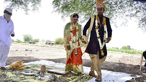 Both are officers in the administration but the marriage is under a tree in farm