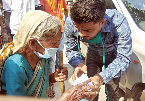 नागपूर : वृद्ध महिलेला सॅनिटायझर व मास्कचे वितरण करताना डॉ. अभिषेक गाडबैल.