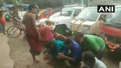A temple priest gives blessings to people by putting his foot on their heads at odhisha