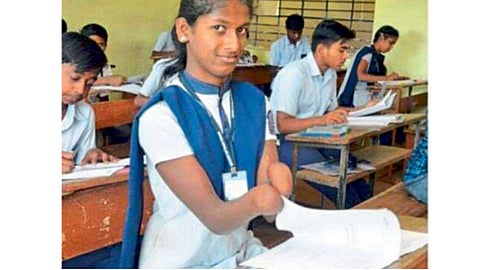 मोरगिरी - चुलीच्या निखाऱ्यात भाजल्याने दोन्ही हातांच्या बोटांसह मनगटापर्यंतचा भाग निकामी झालेली अर्चना यमकर जिद्दीने मनगटात पेन धरून दहावीचे पेपर लिहीत आहे.