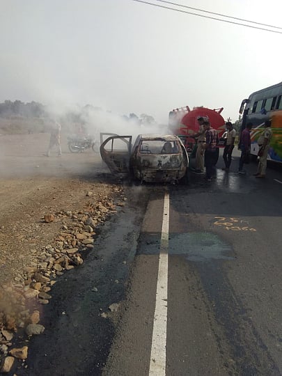 चांपा ः भरधाव असताना पेटलेली कार विझविताना नागरिक.